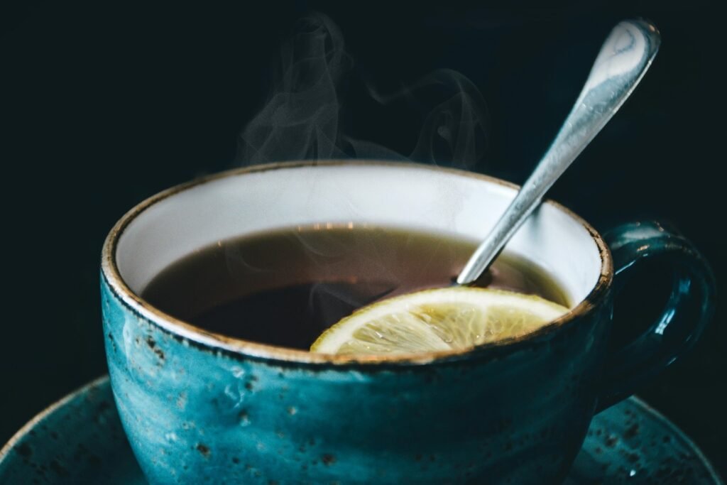 Tea for a sore throat can include lemon, ginger and honey. Tea cup with hot tea.